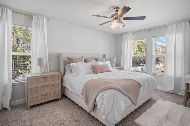 bedroom with baseboards, multiple windows, and light colored carpet