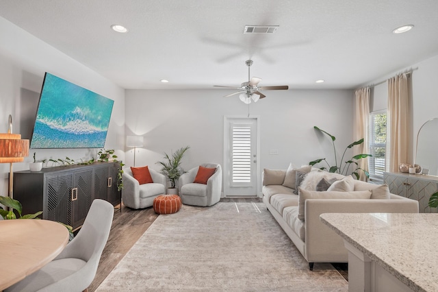 living room with light wood-style floors, recessed lighting, visible vents, and a ceiling fan