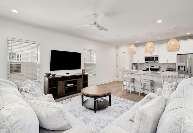 living room with recessed lighting, ceiling fan, baseboards, and light wood-style floors