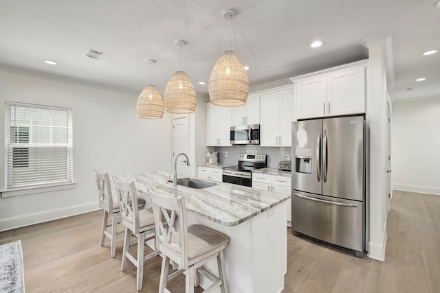kitchen featuring white cabinetry, baseboards, appliances with stainless steel finishes, and a sink
