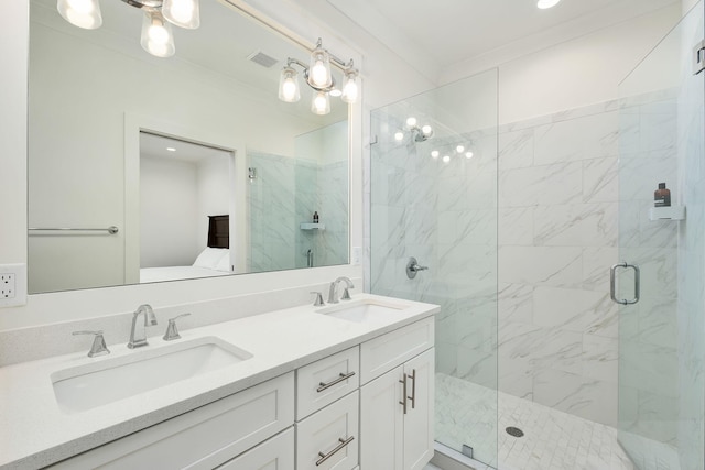 full bath with a marble finish shower, a sink, double vanity, and visible vents