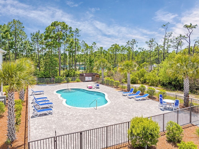 community pool with fence and a patio area