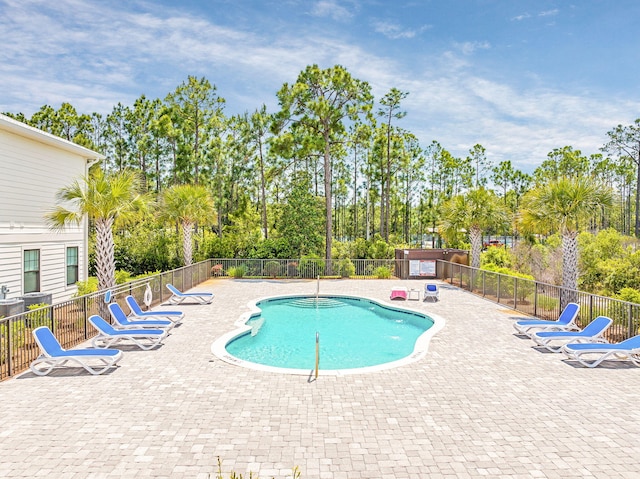pool featuring fence and a patio area