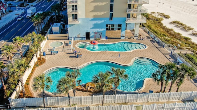 community pool with a patio and fence private yard