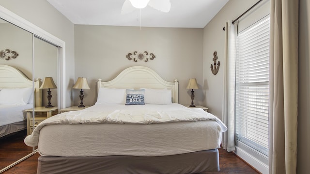 bedroom featuring dark wood-style floors, a closet, and ceiling fan