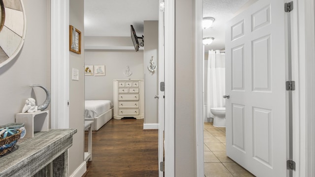 full bathroom featuring wood finished floors, toilet, ensuite bathroom, and baseboards