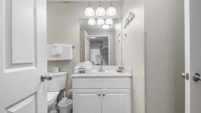half bathroom featuring vanity and toilet