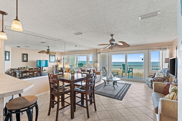 dining space with visible vents, a textured ceiling, light tile patterned flooring, and ceiling fan