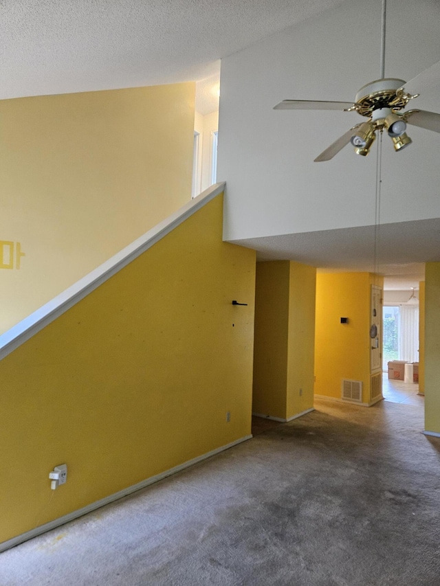 unfurnished living room featuring ceiling fan, carpet, baseboards, and high vaulted ceiling