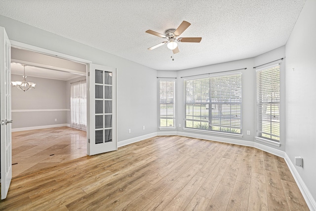 119 Long Pointe Dr, Mary Esther, FL 32569 - spare room featuring a ceiling fan, light wood-style flooring, a textured ceiling, and a chandelier