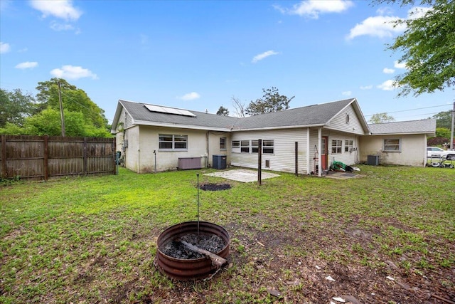 706 Mary Ave, Fort Walton Beach, FL 32547 - rear view of property featuring fence, solar panels, central AC unit, and a lawn