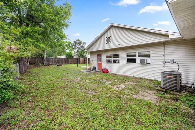 706 Mary Ave, Fort Walton Beach, FL 32547 - back of house with a fenced backyard, central AC unit, cooling unit, and a yard