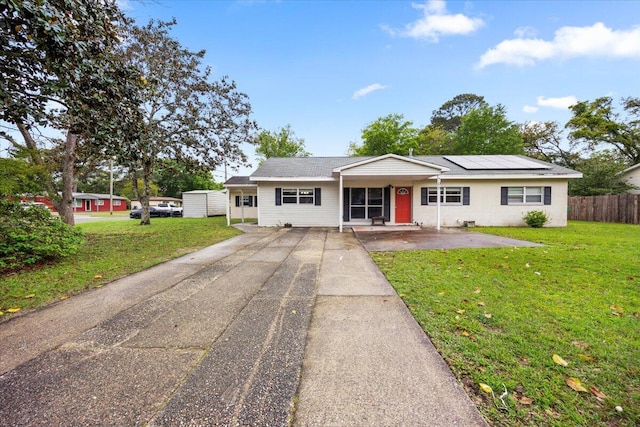 706 Mary Ave, Fort Walton Beach, FL 32547 - ranch-style home with fence, a front lawn, concrete driveway, and solar panels