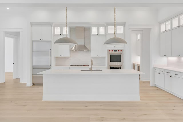 63 W Firethorn Cir Lot 65, Watersound, FL 32461 - kitchen featuring light wood-type flooring, appliances with stainless steel finishes, light countertops, white cabinets, and a kitchen island with sink