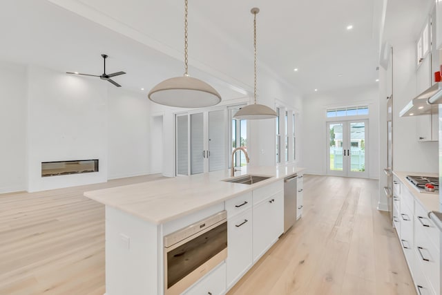 63 W Firethorn Cir Lot 65, Watersound, FL 32461 - kitchen featuring french doors, open floor plan, an island with sink, a ceiling fan, and light wood-style floors