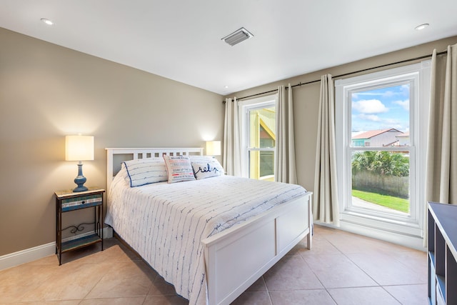 bedroom with baseboards, light tile patterned flooring, and visible vents
