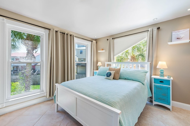bedroom with baseboards and light tile patterned floors