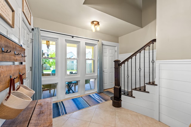foyer featuring stairway, wainscoting, and tile patterned flooring