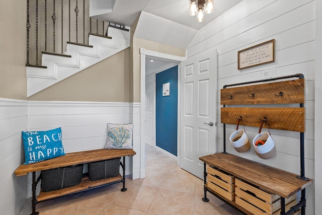foyer entrance with stairway, wainscoting, and light tile patterned flooring