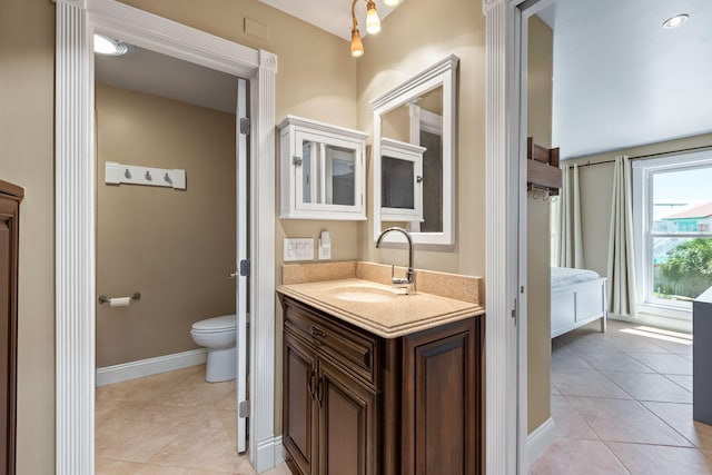 bathroom with vanity, tile patterned flooring, baseboards, and toilet