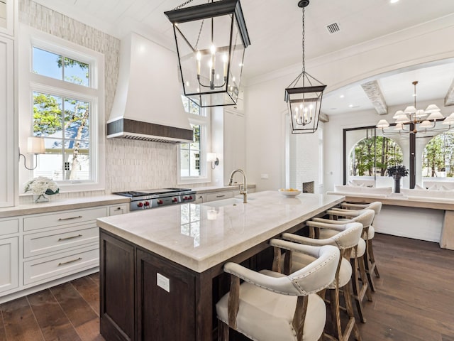 335 Churchill Oaks Dr, Santa Rosa Beach, FL 32459 - kitchen featuring dark wood finished floors, an inviting chandelier, a sink, light stone countertops, and custom range hood