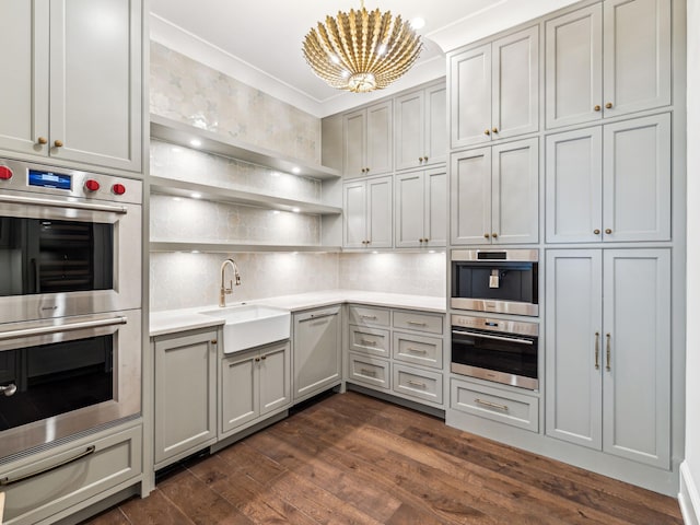 335 Churchill Oaks Dr, Santa Rosa Beach, FL 32459 - kitchen with a sink, dark wood-style flooring, an inviting chandelier, stainless steel double oven, and light countertops