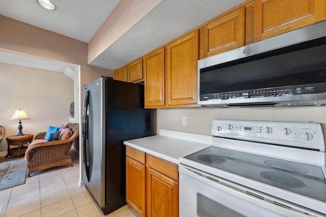 8520 Gulf Blvd # Ut-39, Navarre, FL 32566 - kitchen featuring appliances with stainless steel finishes, light countertops, brown cabinets, and light tile patterned flooring