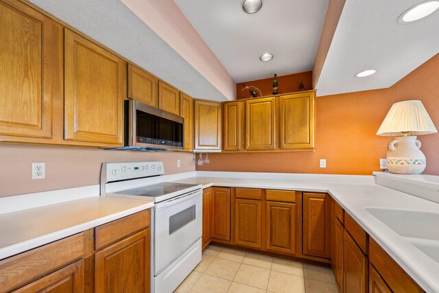 8520 Gulf Blvd # Ut-39, Navarre, FL 32566 - kitchen featuring white electric range oven, stainless steel microwave, light tile patterned flooring, brown cabinetry, and recessed lighting