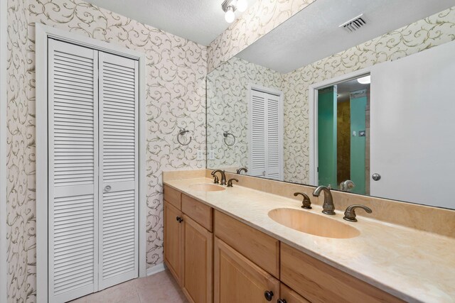 8520 Gulf Blvd # Ut-39, Navarre, FL 32566 - full bath featuring a closet, wallpapered walls, tile patterned floors, double vanity, and a textured ceiling