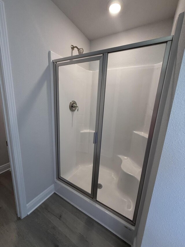 172 Ridgeway Cir, Crestview, FL 32536 - bathroom with baseboards, wood finished floors, and a stall shower