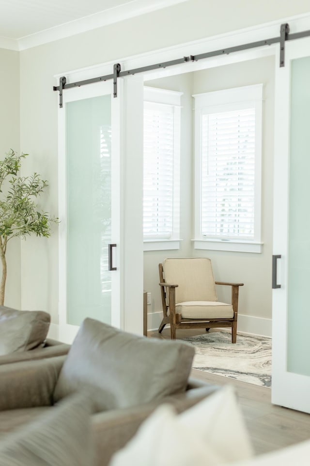 107 Grande Pointe Dr, Inlet Beach, FL 32461 - sitting room featuring a barn door, crown molding, baseboards, and wood finished floors