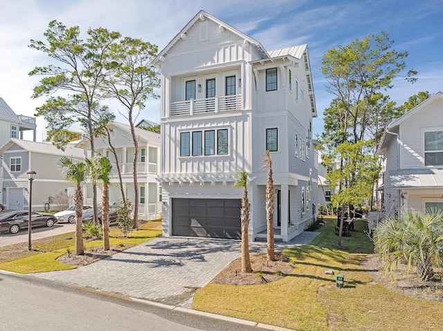 107 Grande Pointe Dr, Inlet Beach, FL 32461 - view of front of house featuring board and batten siding, a balcony, decorative driveway, an attached garage, and a front lawn