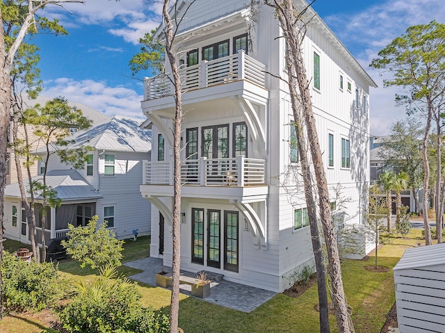 107 Grande Pointe Dr, Inlet Beach, FL 32461 - rear view of house with a balcony, a yard, and board and batten siding