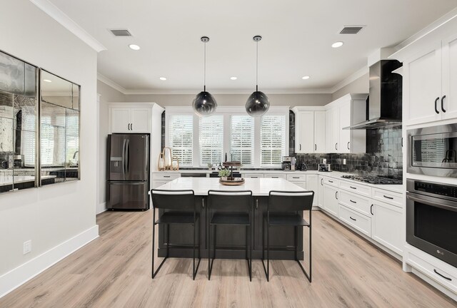 107 Grande Pointe Dr, Inlet Beach, FL 32461 - kitchen with appliances with stainless steel finishes, wall chimney exhaust hood, tasteful backsplash, white cabinets, and crown molding