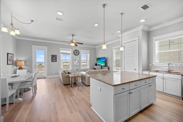 1454 Seaside Cir, Navarre, FL 32566 - kitchen with a sink, crown molding, light wood-style flooring, and visible vents