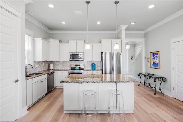 1454 Seaside Cir, Navarre, FL 32566 - kitchen featuring light stone counters, a sink, stainless steel appliances, decorative backsplash, and a kitchen island