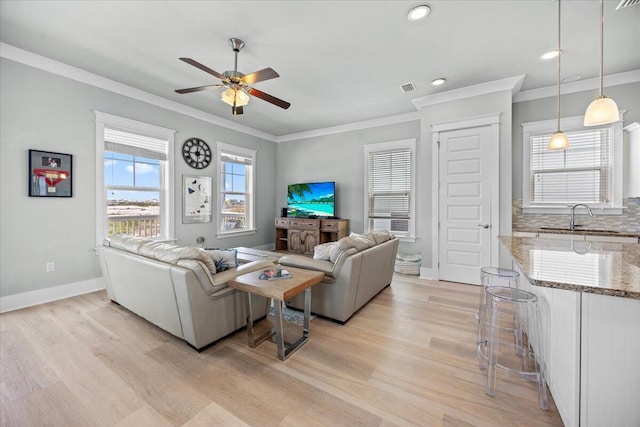 1454 Seaside Cir, Navarre, FL 32566 - living room featuring light wood-type flooring, a ceiling fan, crown molding, and visible vents