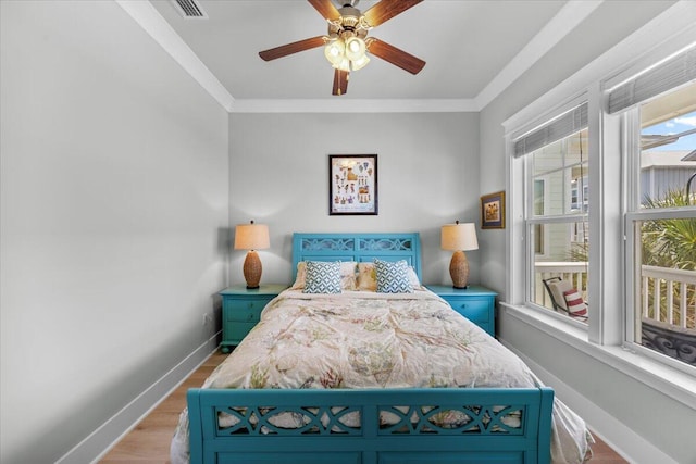 1454 Seaside Cir, Navarre, FL 32566 - bedroom with crown molding, baseboards, visible vents, and wood finished floors