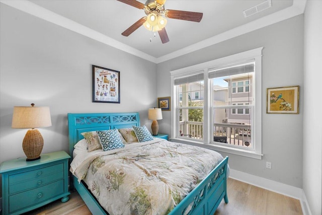 1454 Seaside Cir, Navarre, FL 32566 - bedroom with crown molding, ceiling fan, light wood finished floors, baseboards, and visible vents