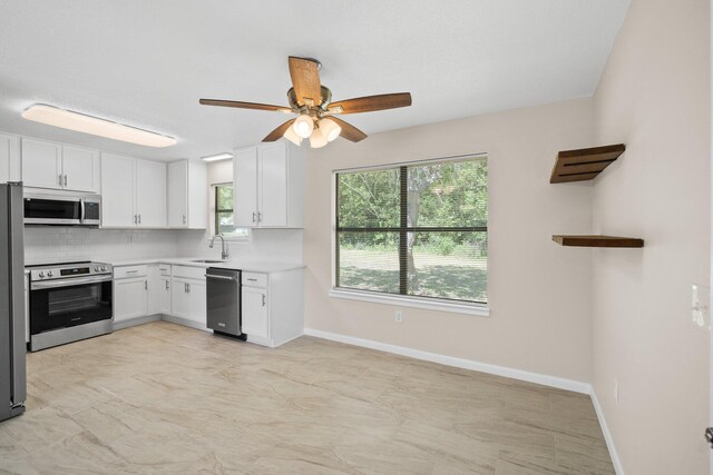 3335 Rolling Hills Cir, Bonifay, FL 32425 - kitchen with ceiling fan, white cabinets, a sink, stainless steel appliances, and backsplash