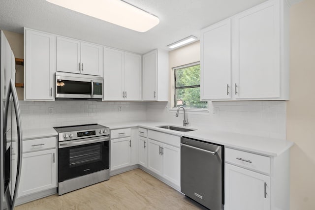 3335 Rolling Hills Cir, Bonifay, FL 32425 - kitchen with tasteful backsplash, white cabinets, a sink, light countertops, and stainless steel appliances