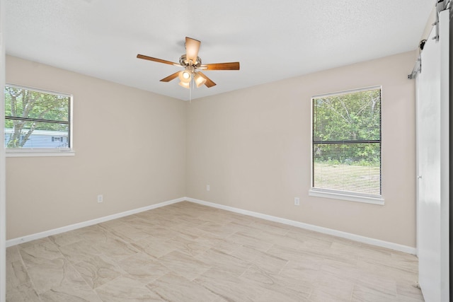 3335 Rolling Hills Cir, Bonifay, FL 32425 - spare room with a wealth of natural light, a barn door, baseboards, and a ceiling fan