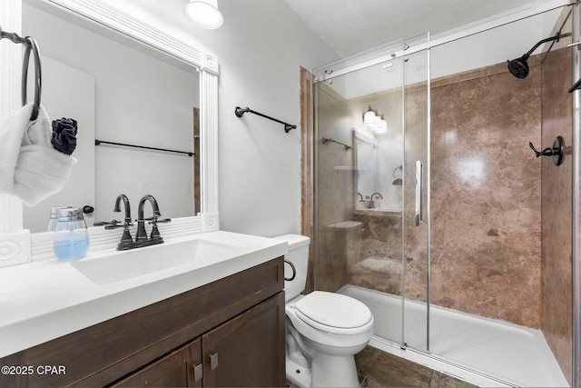 full bathroom featuring toilet, a stall shower, and vanity