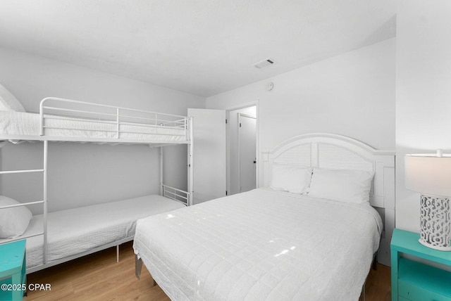 bedroom with visible vents and wood finished floors