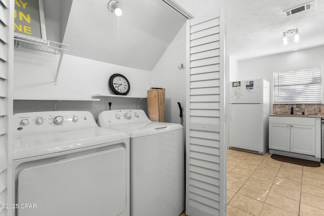 washroom featuring light tile patterned floors, visible vents, independent washer and dryer, laundry area, and a sink