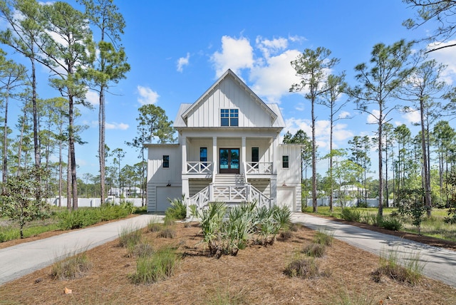 205 Mallard Ln, Santa Rosa Beach, FL 32459 - raised beach house with concrete driveway, stairway, board and batten siding, and covered porch