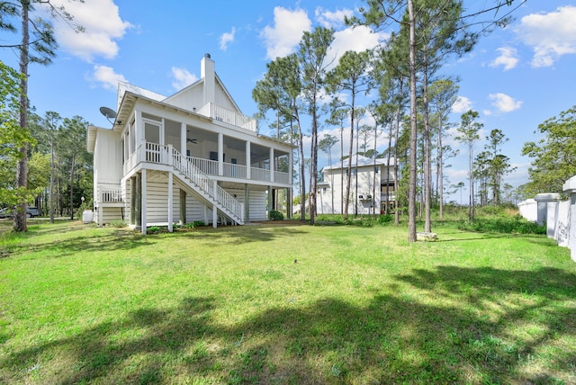 205 Mallard Ln, Santa Rosa Beach, FL 32459 - back of house featuring a lawn, a chimney, a ceiling fan, a sunroom, and stairs