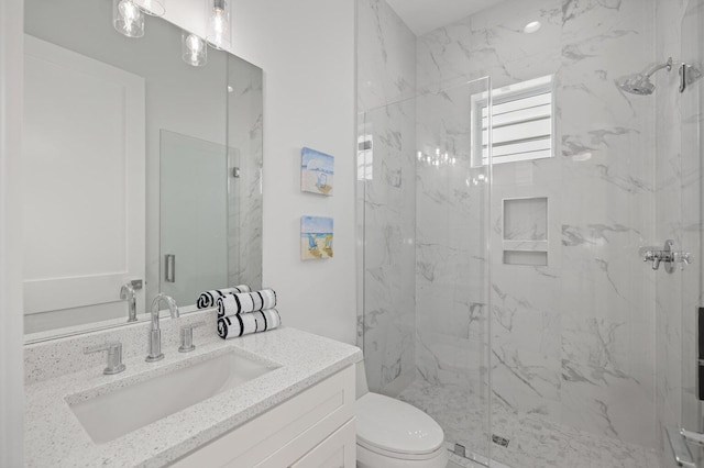 full bath with vanity, toilet, and a marble finish shower