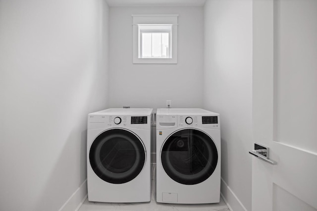 laundry room featuring washing machine and dryer, laundry area, and baseboards