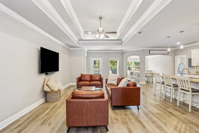 3291 Secret Isle Way, Navarre, FL 32566 - living room featuring arched walkways, a raised ceiling, ceiling fan, light wood-style floors, and baseboards